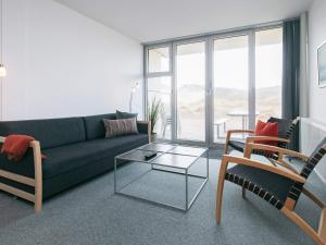 a living room with a couch and a glass table at Apartment on a holiday park in Blokhus in Blokhus