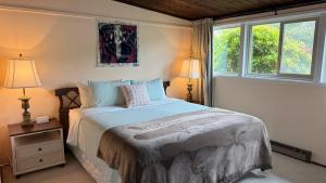 a bedroom with a bed and two windows at Arky's B&B in Smith River