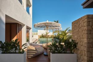 a patio with an umbrella and a swimming pool at Ananda Mojácar - Only Adults in Mojácar