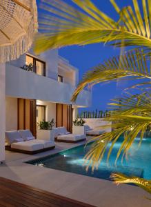 a villa with a swimming pool and a palm tree at Ananda Mojácar - Only Adults in Mojácar