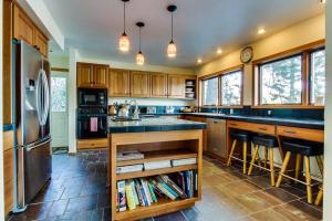 a kitchen with wooden cabinets and a stainless steel refrigerator at Lake House Private Dock & Decks 4BR in Hayden