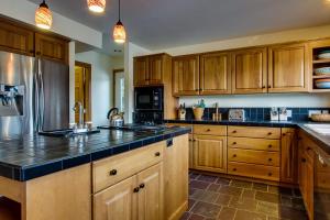 a large kitchen with wooden cabinets and black counter tops at Lake House Private Dock & Decks 4BR in Hayden