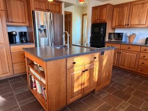 a kitchen with wooden cabinets and a stainless steel refrigerator at Lake House Private Dock & Decks 4BR in Hayden