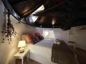 a bedroom with a bed and a table with a lamp at Moinho do Barulho in São Bartolomeu de Messines +87 photos