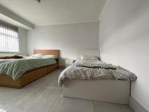 a bedroom with a bed and a white wall at Instant Home in Luton
