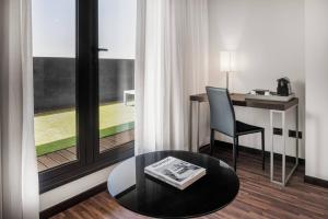 a room with a table and a chair and a window at AC Hotel Algeciras by Marriott in Algeciras +37 photos