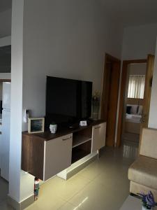 a living room with a flat screen tv on a entertainment center at EJ&A Coastal Suites in Marsaskala