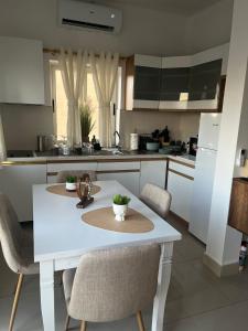 a kitchen with a white table and chairs at EJ&A Coastal Suites in Marsaskala