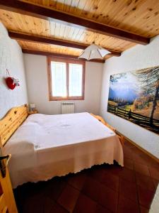 a bedroom with a large bed with a painting on the wall at Casa vacanze Pievepelago in Pievepelago