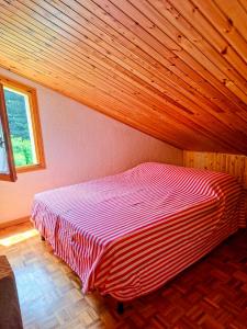 a bed in a room with a wooden ceiling at Casa vacanze Pievepelago in Pievepelago +5 photos