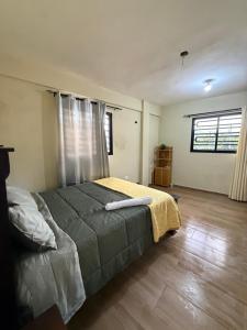 a bedroom with a bed with a yellow blanket on it at La casita de Polo in Polo