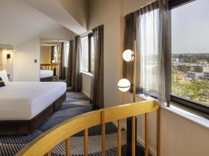 a hotel room with a bed and a window at Novotel Sydney Parramatta in Sydney +126 photos