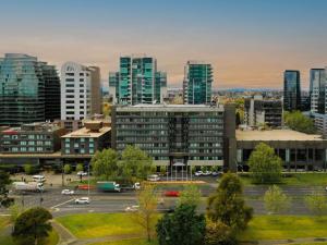 a city skyline with a parking lot and buildings at Pullman Melbourne Albert Park in Melbourne