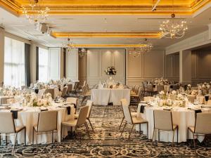 a banquet room with tables and chairs and chandeliers at The Playford Adelaide - MGallery in Adelaide +142 photos