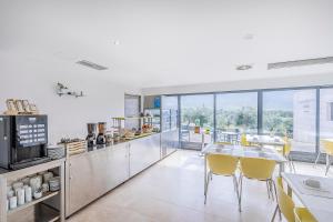 a kitchen with a table and yellow chairs in it at HI Alvados - Pousada de Juventude in Alvados +15 photos