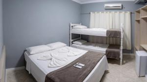 a room with two bunk beds in a room at Pousada Ilha do Itacolomi in Penha