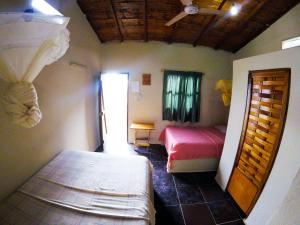 a bedroom with two beds in a room with a ceiling at Montañita Garden Hostal in Montañita