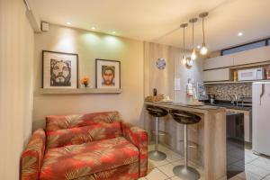 a living room with a couch and a kitchen at Atlântico Flat Beira Mar in Natal