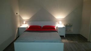 - une chambre avec un lit doté d'oreillers rouges dans l'établissement Ninna Nanna, à Fondi