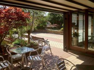a patio with a table and chairs and a window at Mercure Bergamo Aeroporto in Stezzano