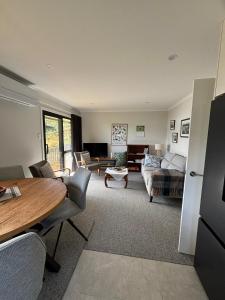 a living room with a table and a couch at Raynbird Cottage in Dunedin