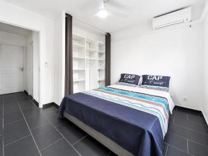 a bedroom with a large bed in a white room at Villa 6 pers Jacuzzi Centre Guadeloupe in Petit-Bourg