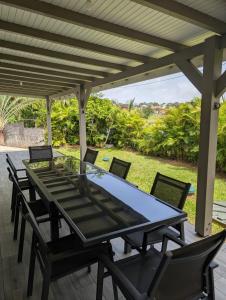 a table and chairs on a patio with a pergola at Villa 6 pers Jacuzzi Centre Guadeloupe in Petit-Bourg