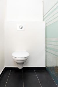 a bathroom with a toilet in a white wall at Villa 6 pers Jacuzzi Centre Guadeloupe in Petit-Bourg +14 photos