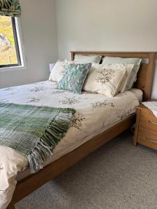 a bed with pillows on it in a bedroom at Raynbird Cottage in Dunedin