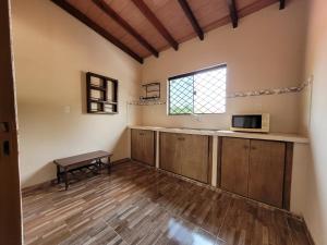 a room with a kitchen with a microwave and a table at Don Roque in Piribebuy +1 photo