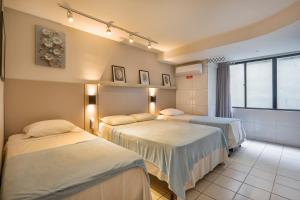 a hospital room with three beds and a window at Atlântico Flat Beira Mar in Natal