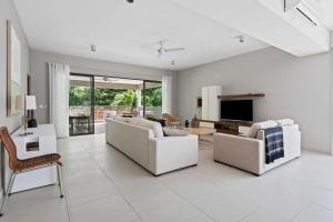 a living room with two white couches and a tv at Element Bay 5 in Cap Malheureux