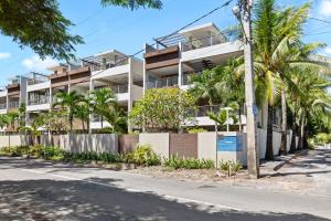 an apartment building with palm trees in front of a street at Element Bay 5 in Cap Malheureux