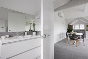 a white bathroom with a sink and a dining room at The Stables in Newstead