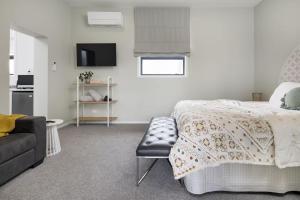 a bedroom with a bed and a couch and a tv at The Stables in Newstead