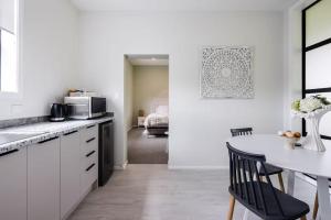 a white kitchen with a table and a black chair at The Stables in Newstead