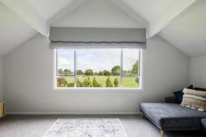 a living room with a window and a couch at The Stables in Newstead +5 photos