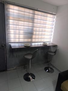 a counter with two stools in a room with a window at Práctico y céntrico departamento in Salamanca +2 photos