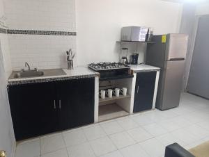 a small kitchen with a stove and a refrigerator at Práctico y céntrico departamento in Salamanca
