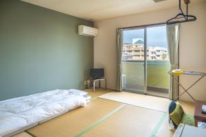 a bedroom with a bed and a large window at 美咲旅館 in Sakaide +67 photos