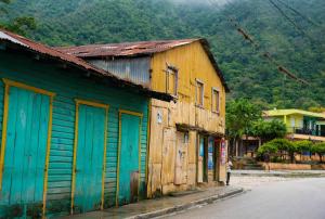 an old wooden building with blue doors on a street at La casita de Polo in Polo