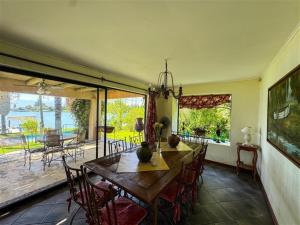 a dining room with a wooden table and chairs at El Estero Lago Rapel in El Estero
