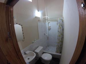 a small bathroom with a toilet and a sink at Montañita Garden Hostal in Montañita +33 photos