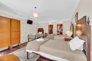a bedroom with two beds and a tv in it at Old City Guest House in Braga