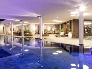 a lobby with a swimming pool and columns at Stadtchalet Forsthaus in Kitzbühel
