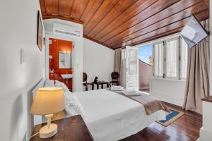 a bedroom with a bed and a table with a lamp at Old City Guest House in Braga