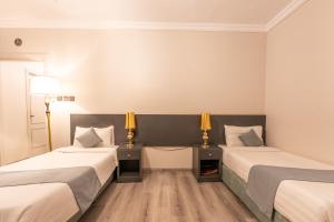 a hotel room with two beds and two lamps at عالم الضيافة in Al ‘Azīzīyah +5 photos