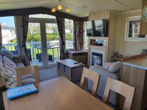 a living room with a table and a couch at 3-Bed Caravan Sleeps 8 with Enclosed Decking in Fleetwood