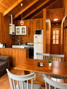 a kitchen with a wooden table and white appliances at Turismo La Isla in Salto del Laja