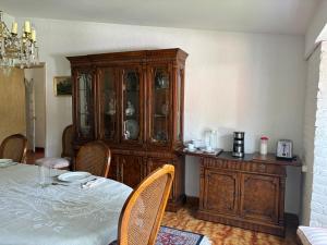 a dining room with a table and a wooden cabinet at Habitacion en residencia compartida in Mexico City